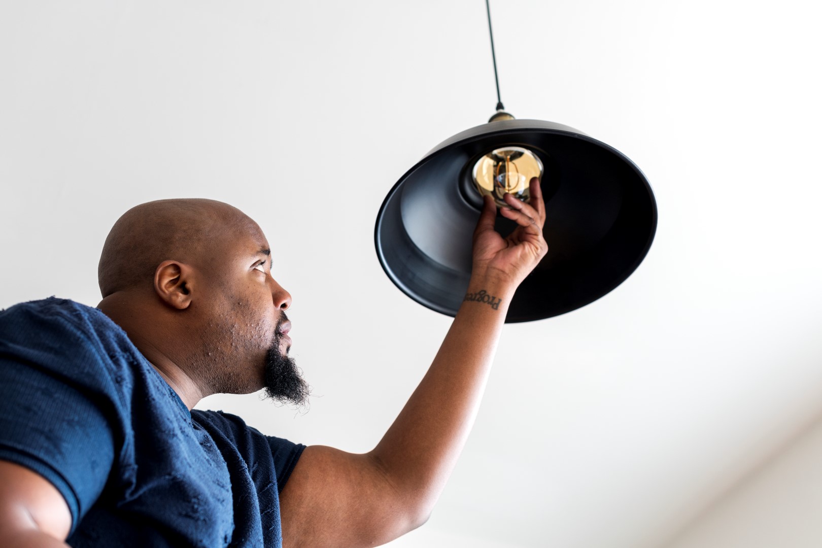 man changing a lightbulb in a lamp